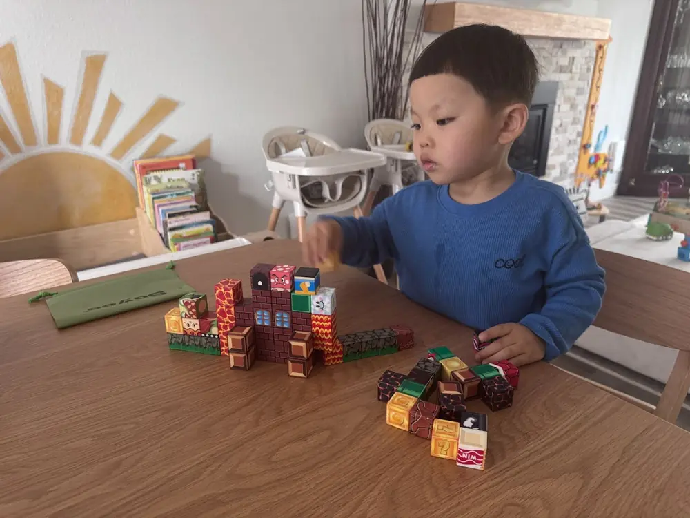 Preschool children building towers with wooden blocks at Kido Heaven Child Care in Bothell, WA
