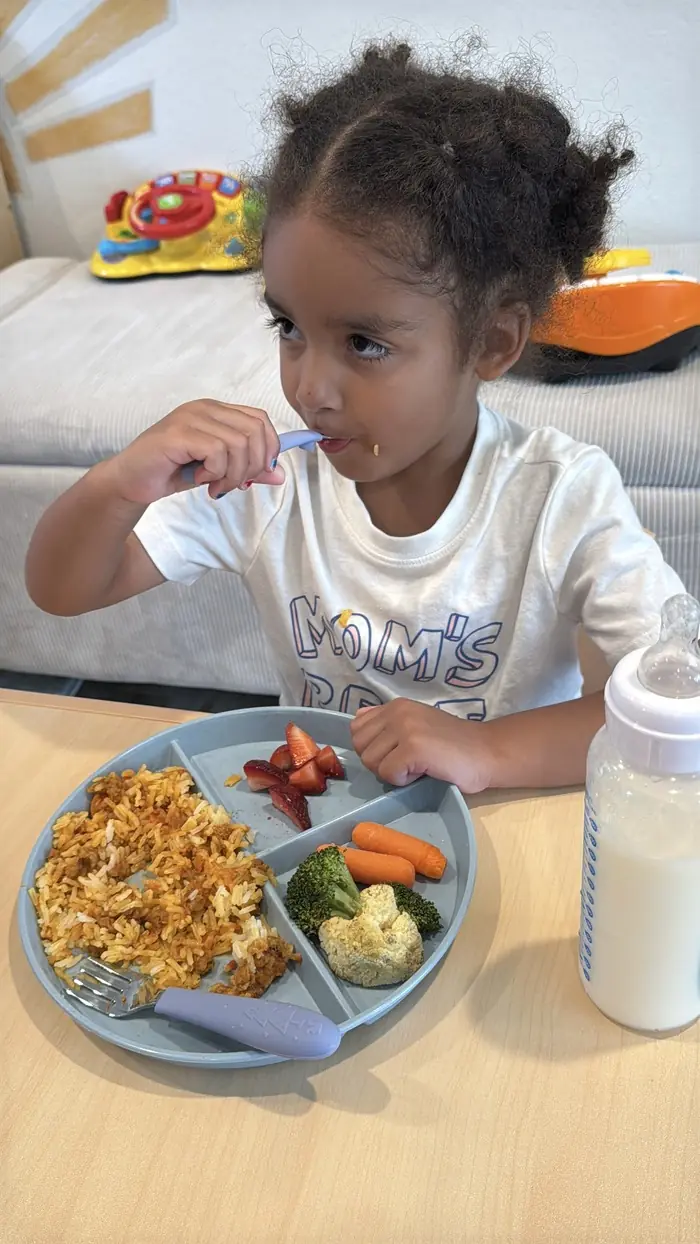 Toddler eating a balanced meal at daycare bothell.