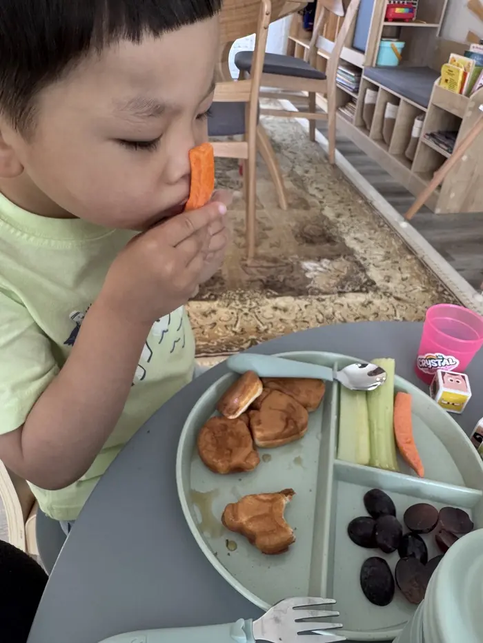 Children sorting colorful vegetables in a fun food play game at Kidoheaven child care in Bothell, enhancing fine motor skills and food familiarity. 