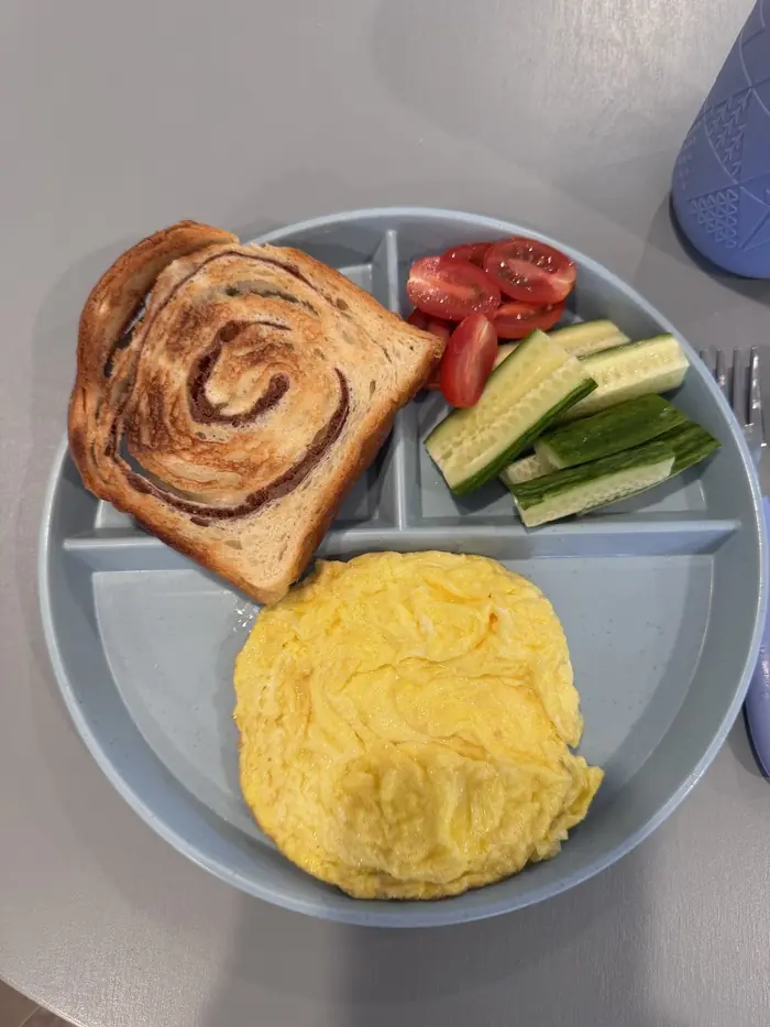 Colorful toddler meal in a divided plate at Kidoheaven child care in Bothell, promoting healthy eating through fun food play activities. 