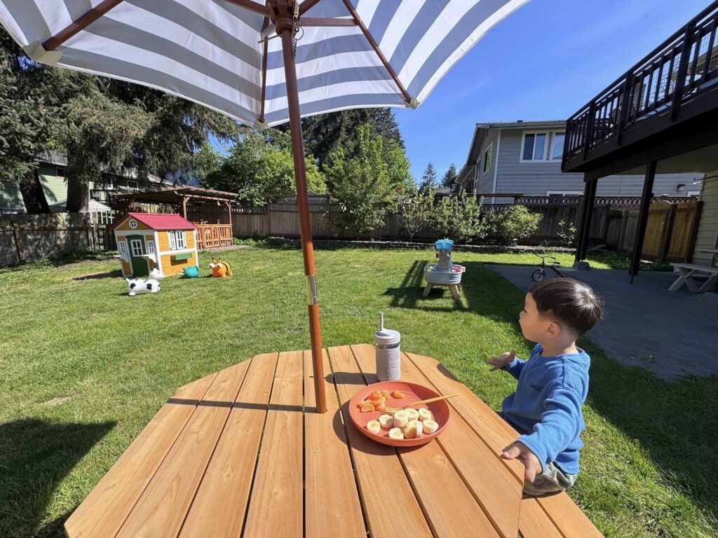 Child eating healthy snacks during outdoor mealtime at Kido Heaven Daycare in Bothell