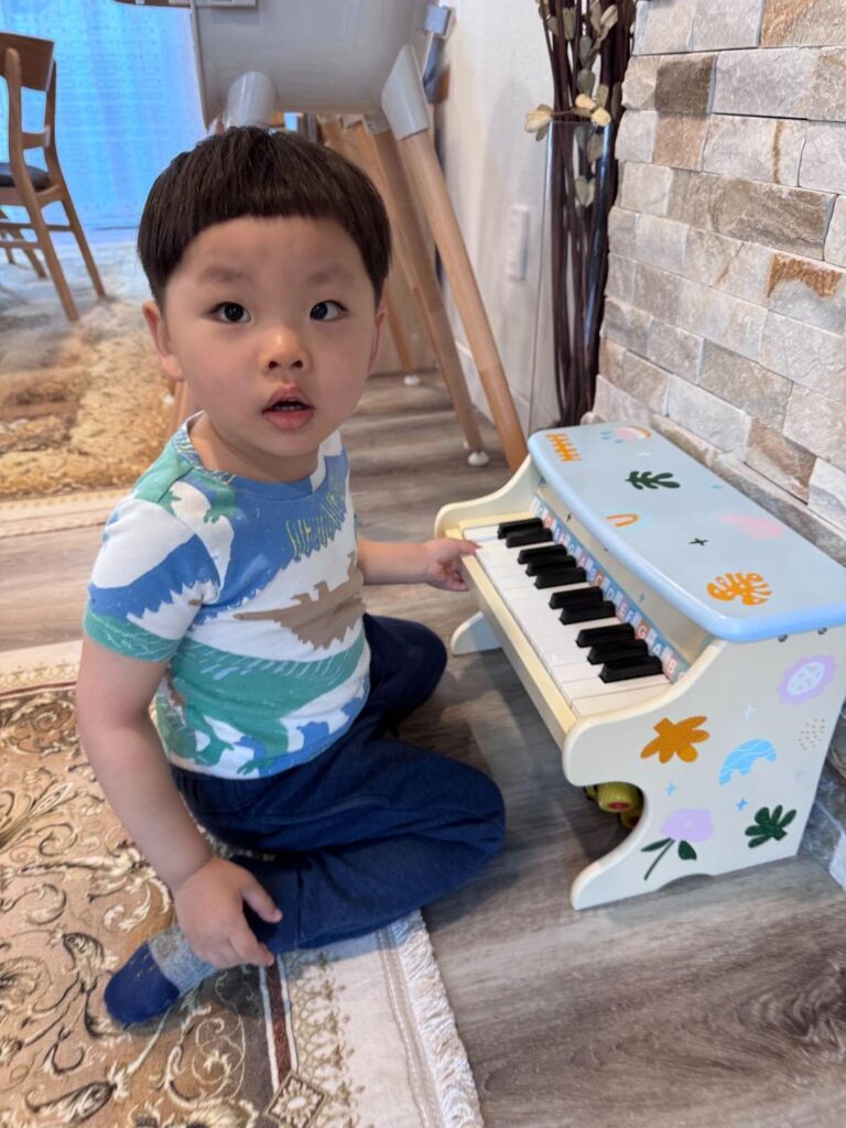 Kids exploring music with toy piano in Montessori classroom
