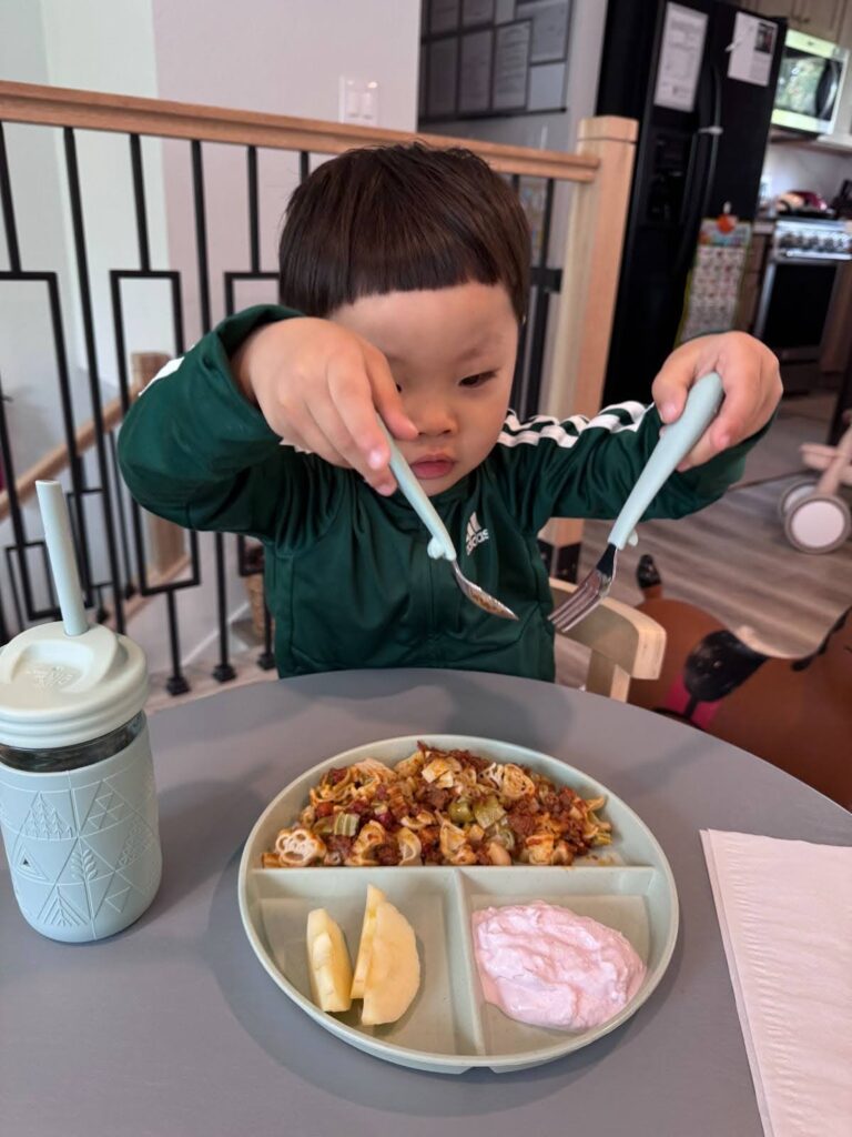 Child with sensory needs enjoying mealtime at Kido Heaven Child Care in Bothell, WA.