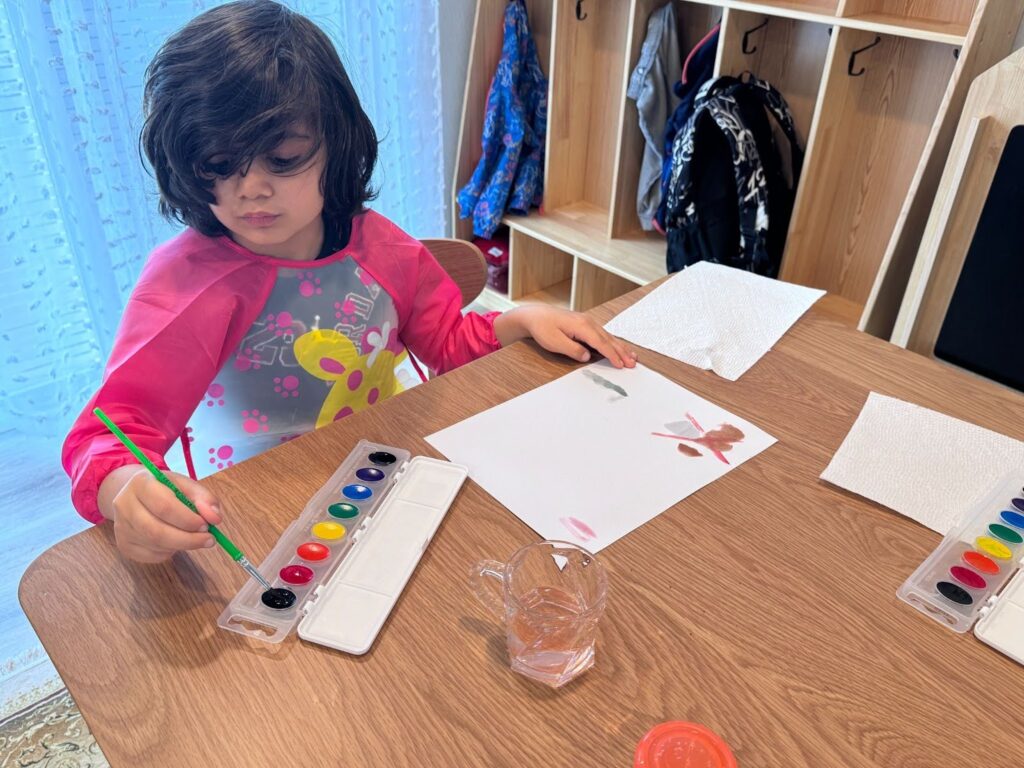 Child painting to develop fine motor skills in Bothell daycare