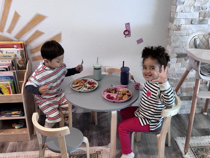 Preschool children eating together, practicing positive social behaviors in a classroom