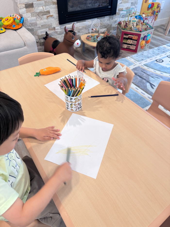 Infants engaging in parallel play with sensory materials at daycare