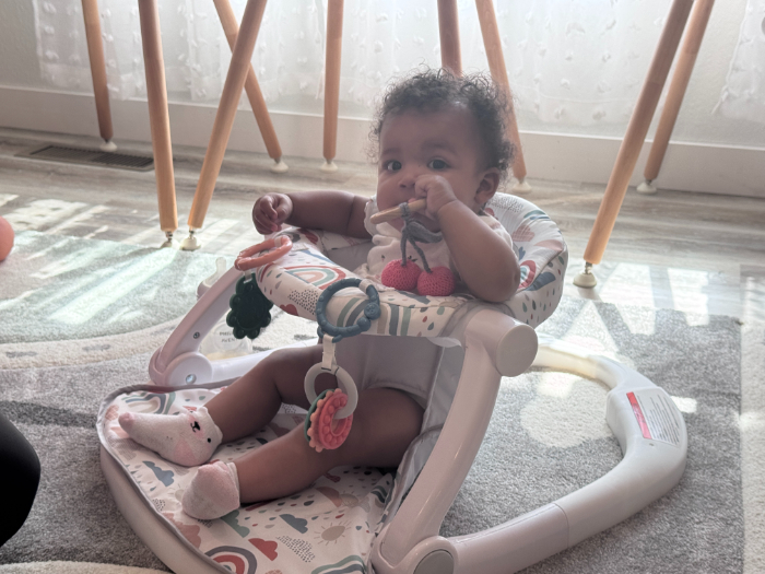 Happy infant lying safely in modern crib with breathable mattress – safe home environment for daycare babies