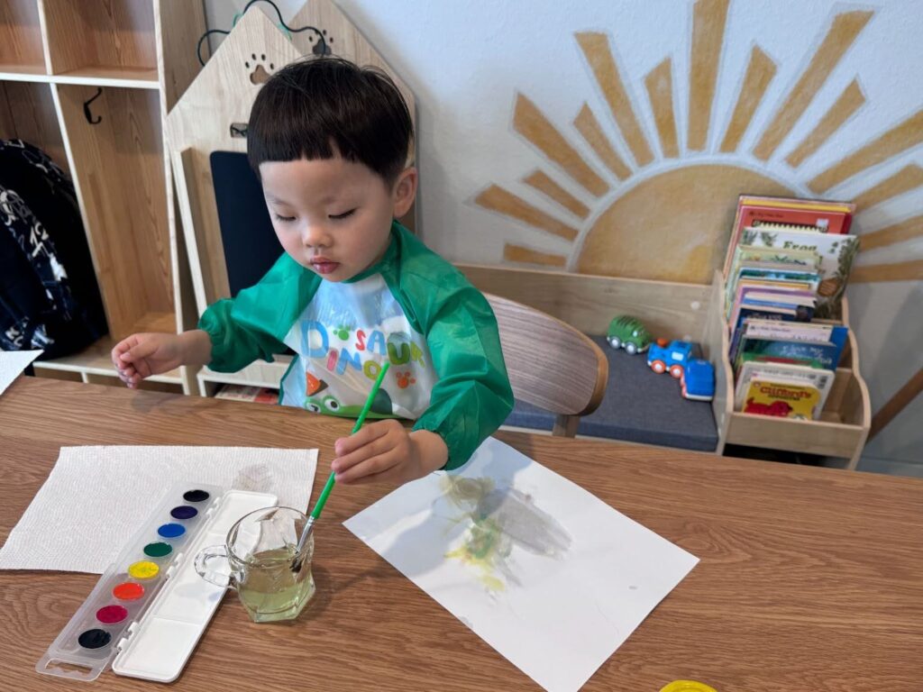 Child painting with watercolor in calm environment