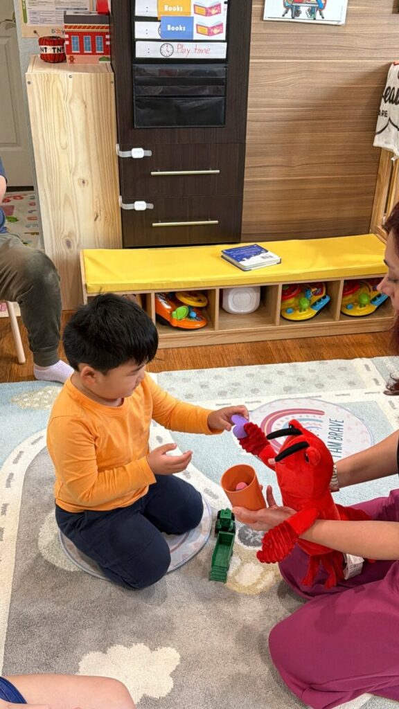 Early childhood educator facilitating puppet activity